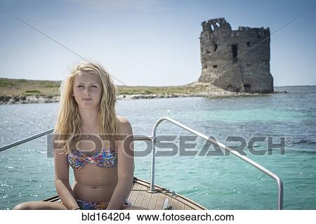 Smiling girl sunbathing on sailboat near ancient ruins View Large Photo Image Picture - Smiling girl sunbathing on sailboat near ancient ruins. Fotosearch
