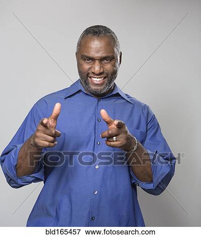 Smiling older African American man pointing View Large Photo Image Stock Photo - Smiling older African American man pointing. Fotosearch