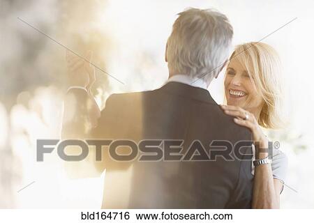 Stock Photograph - Smiling older Caucasian couple dancing. Fotosearch