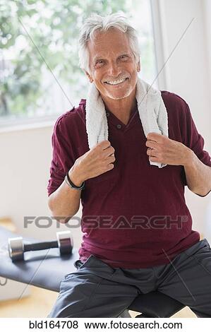 Smiling older Caucasian man resting in gym View Large Photo Image Stock Photo - Smiling older Caucasian man resting in gym. Fotosearch