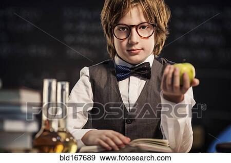 Stock Photo - Student holding apple and studying. Fotosearch