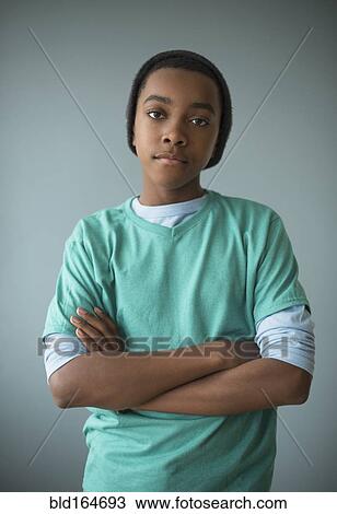 Stylish Black boy standing with arms crossed View Large Photo Image Stock Image - Stylish Black boy standing with arms crossed. Fotosearch
