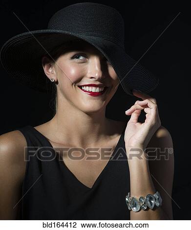 Stylish Caucasian woman wearing black hat and dress View Large Photo Image Stock Image - Stylish Caucasian woman wearing black hat and dress. Fotosearch