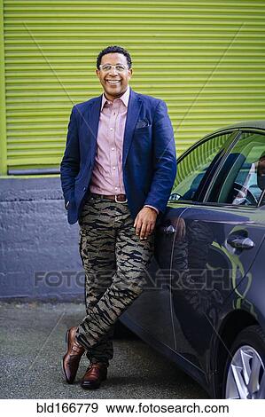 Stylish Mixed race businessman leaning on car View Large Photo Image Stock Photo - Stylish Mixed race businessman leaning on car. Fotosearch