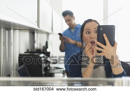Surprised businesswoman using digital tablet in office View Large Photo Image Picture - Surprised businesswoman using digital tablet in office. Fotosearch
