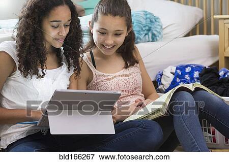 Stock Photo - Teenage girls using digital tablet in bedroom. Fotosearch