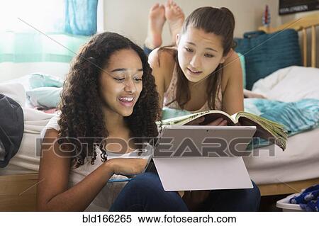 Teenage girls using digital tablet on bed View Large Photo Image Stock Photography - Teenage girls using digital tablet on bed. Fotosearch