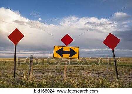 Picture - Traffic sign in remote field under clouds. Fotosearch