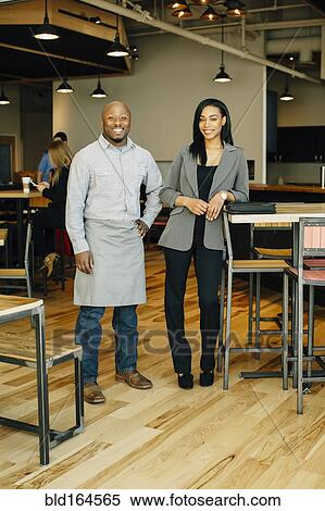 Stock Photography - Waiter and businesswoman smiling in cafe. Fotosearch