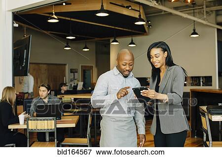 Waiter and businesswoman using digital tablet in cafe View Large Photo Image Stock Photo - Waiter and businesswoman using digital tablet in cafe. Fotosearch