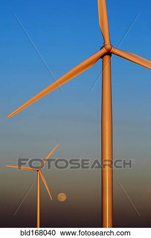 Wind turbines against sunset sky with rising moon View Large Photo Image Stock Image - Wind turbines against sunset sky with rising moon. Fotosearch