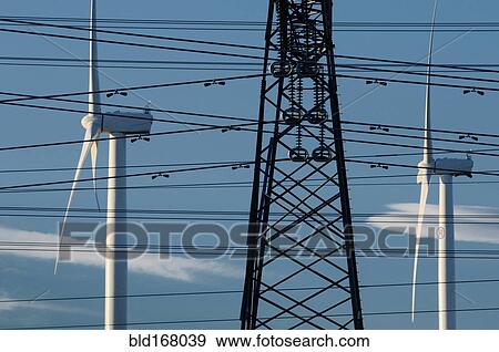 Wind turbines and power lines under blue sky View Large Photo Image Stock Photo - Wind turbines and power lines under blue sky. Fotosearch