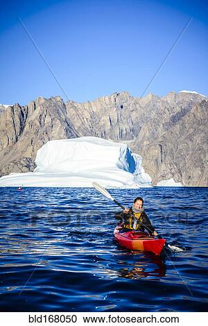 Woman paddling canoe near glaciers in remote river View Large Photo Image Stock Image - Woman paddling canoe near glaciers in remote river. Fotosearch