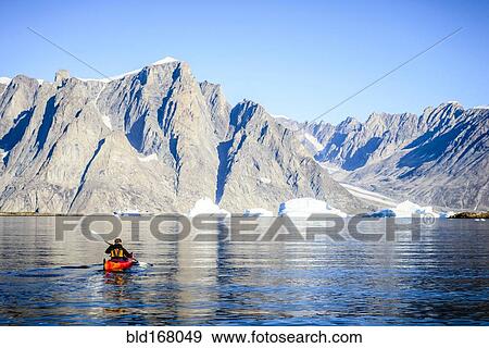 Woman paddling canoe towards glaciers in remote river View Large Photo Image Stock Photo - Woman paddling canoe towards glaciers in remote river. Fotosearch