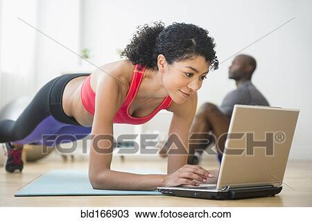 Woman using computer and doing push-ups in gym View Large Photo Image Stock Image - Woman using computer and doing push-ups in gym. Fotosearch