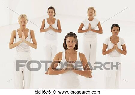 Stock Image - Women meditating in yoga class. Fotosearch