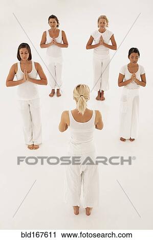 Stock Image - Women meditating in yoga class. Fotosearch