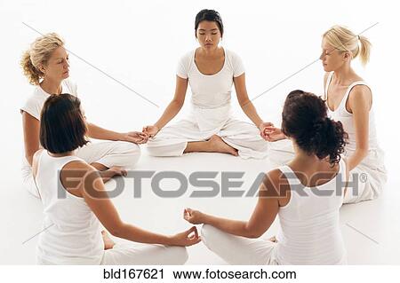 Stock Image - Women meditating in yoga class. Fotosearch