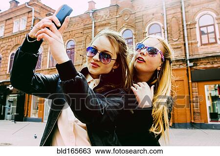Women taking selfie in city View Large Photo Image Stock Image - Women taking selfie in city. Fotosearch