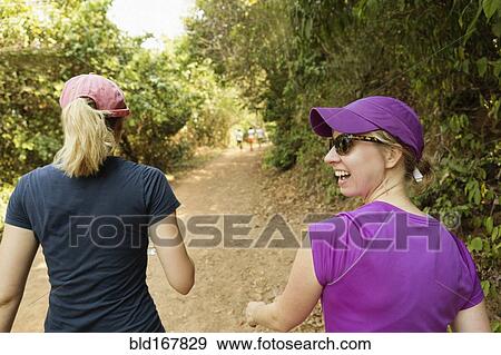 Women walking on remote dirt path View Large Photo Image Stock Photo - Women walking on remote dirt path. Fotosearch