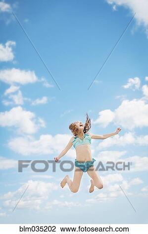 コーカサス人 女の子 喜びのためのジャンプ 中に 青い空 ストックイメージ Blm0352 Fotosearch