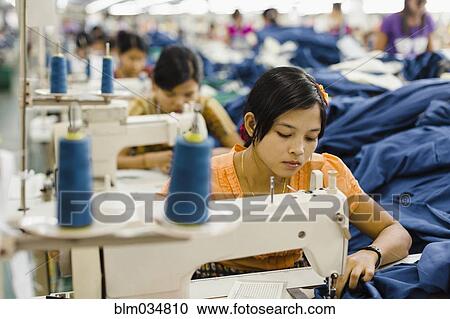 Asian worker sewing clothing in garment factory View Large Photo Image Stock Image - Asian worker sewing clothing in garment factory. Fotosearch