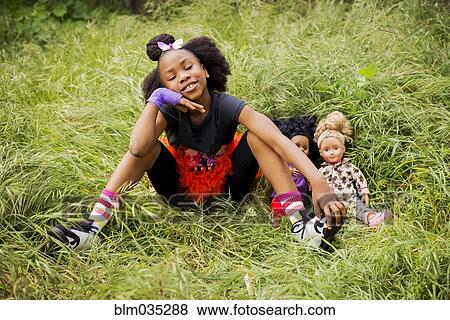 Black girl playing with dolls in tall grass View Large Photo Image Stock Photo - Black girl playing with dolls in tall grass. Fotosearch