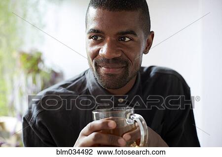 Stock Image - Black man drinking cup of tea. Fotosearch