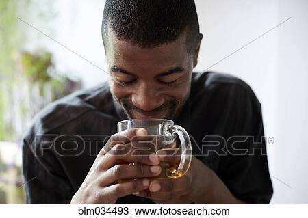 Stock Image - Black man drinking cup of tea. Fotosearch