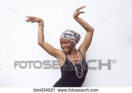 Stock Image - Black woman posing with arms raised. Fotosearch