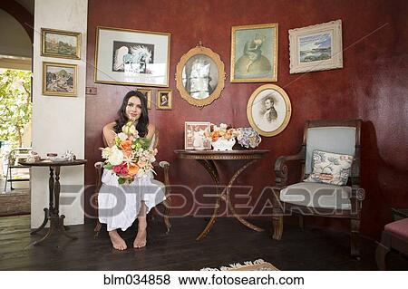 Stock Photo - Bride holding bouquet of flowers in waiting room. Fotosearch