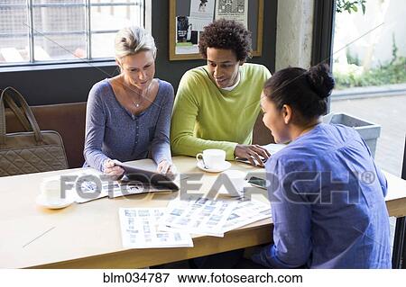 Stock Photo - Business people using digital tablet in office meeting. Fotosearch