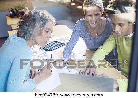 Stock Photo - Business people using laptop in office meeting. Fotosearch