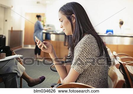 Businesswoman using cell phone in waiting area View Large Photo Image Stock Photograph - Businesswoman using cell phone in waiting area. Fotosearch