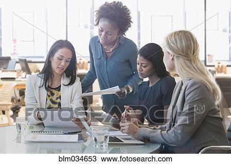 Stock Image - Businesswomen talking in office meeting. Fotosearch