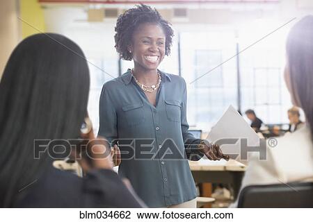 Stock Image - Businesswomen talking in office meeting. Fotosearch