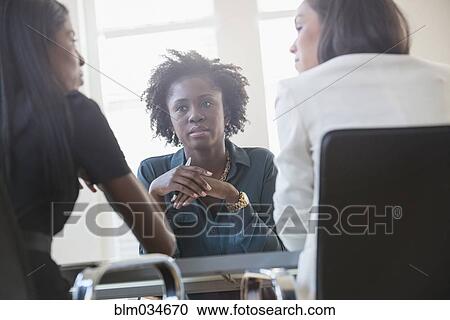 Businesswomen talking in office meeting View Large Photo Image Stock Image - Businesswomen talking in office meeting. Fotosearch