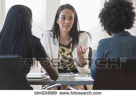 Stock Photo - Businesswomen talking in office meeting. Fotosearch