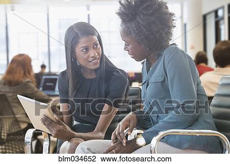 Stock Image - Businesswomen using digital tablet in office. Fotosearch