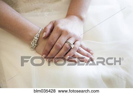 Stock Photo - Caucasian bride wearing rings and wedding gown. Fotosearch