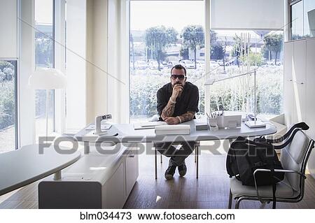 Stock Image - Caucasian businessman sitting in modern office. Fotosearch