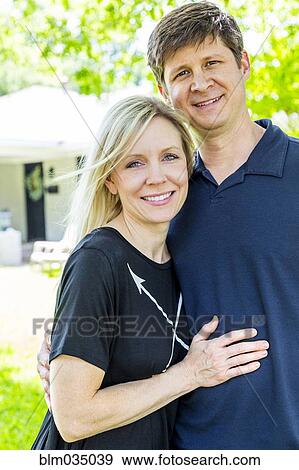 Caucasian couple hugging in backyard View Large Photo Image Stock Photo - Caucasian couple hugging in backyard. Fotosearch