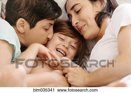 Caucasian family cuddling in bed View Large Photo Image Stock Image - Caucasian family cuddling in bed. Fotosearch