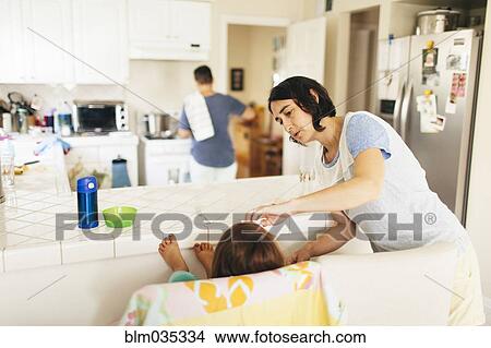 Picture - Caucasian family having breakfast in kitchen. Fotosearch