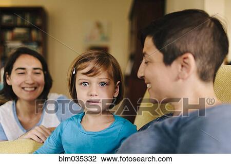 Stock Image - Caucasian family sitting in living room. Fotosearch