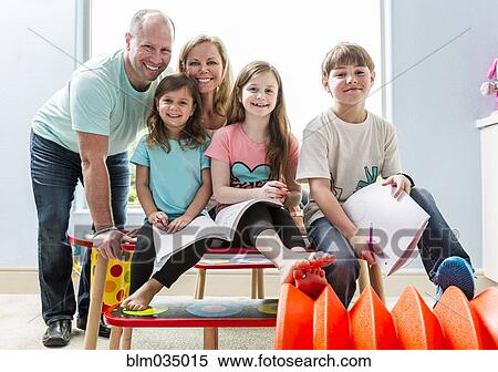 Caucasian family smiling at table in playroom View Large Photo Image Stock Photography - Caucasian family smiling at table in playroom. Fotosearch