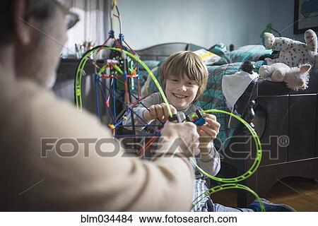 Caucasian father and son playing with toys in bedroom View Large Photo Image Picture - Caucasian father and son playing with toys in bedroom. Fotosearch
