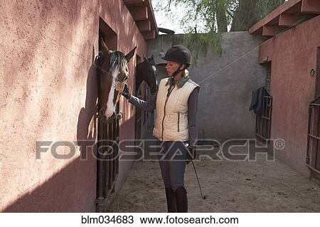 Caucasian girl examining horse in stable on ranch View Large Photo Image Stock Image - Caucasian girl examining horse in stable on ranch. Fotosearch