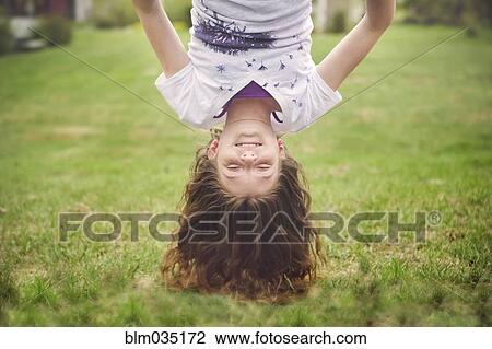 Caucasian girl hanging upside down in backyard View Large Photo Image Stock Image - Caucasian girl hanging upside down in backyard. Fotosearch