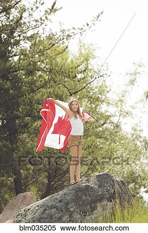 Caucasian girl holding Canadian flag on boulder View Large Photo Image Stock Photography - Caucasian girl holding Canadian flag on boulder. Fotosearch